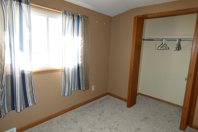 carpeted bedroom with a closet and lofted ceiling