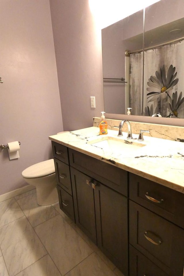 bathroom featuring curtained shower, vanity, and toilet