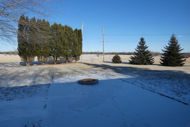 view of yard with an outdoor fire pit and a rural view