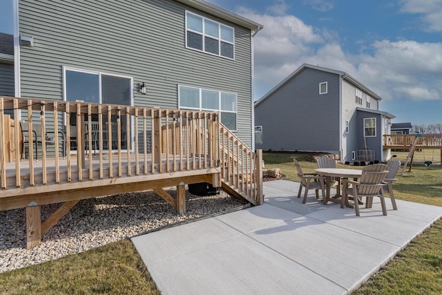 rear view of house with a wooden deck and a patio area