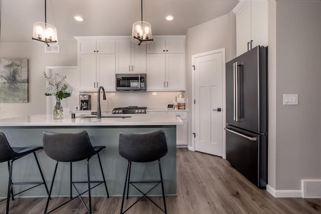 kitchen with white cabinetry, pendant lighting, and high end fridge