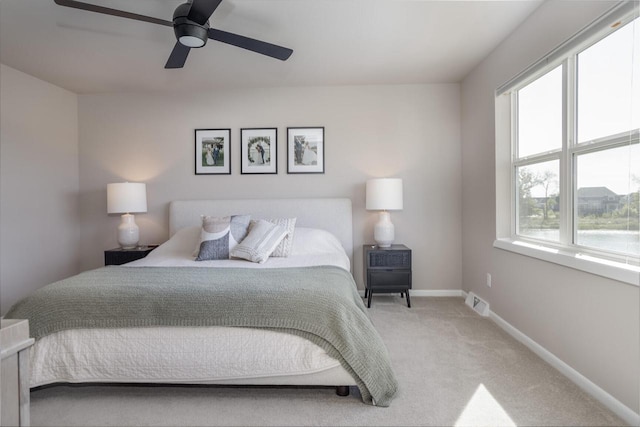 carpeted bedroom featuring ceiling fan and multiple windows