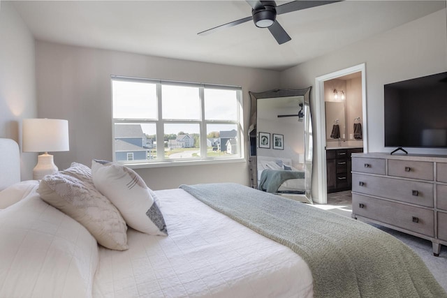 carpeted bedroom with ensuite bathroom and ceiling fan