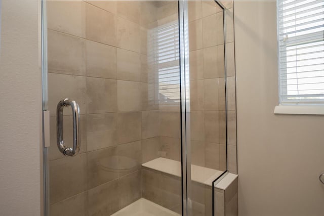 bathroom featuring a shower with door