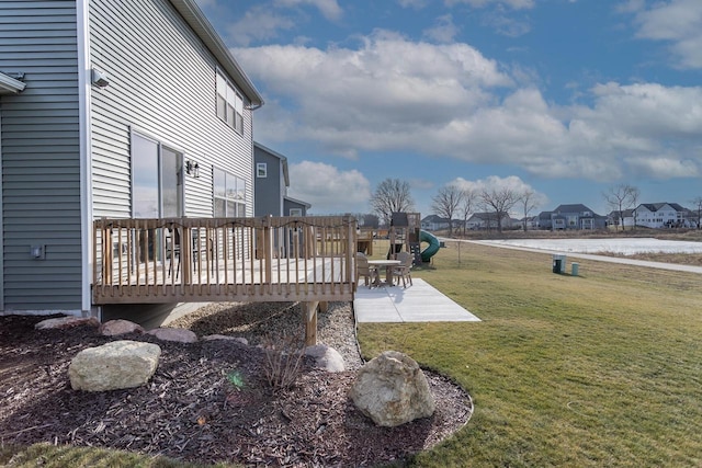 view of yard featuring a wooden deck, a playground, and a patio area