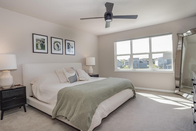 bedroom with ceiling fan and light colored carpet