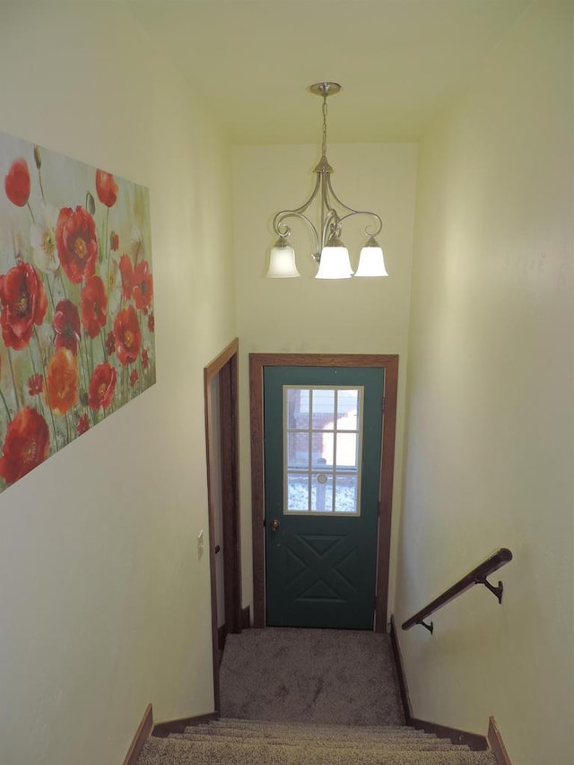 doorway to outside with carpet floors and a notable chandelier