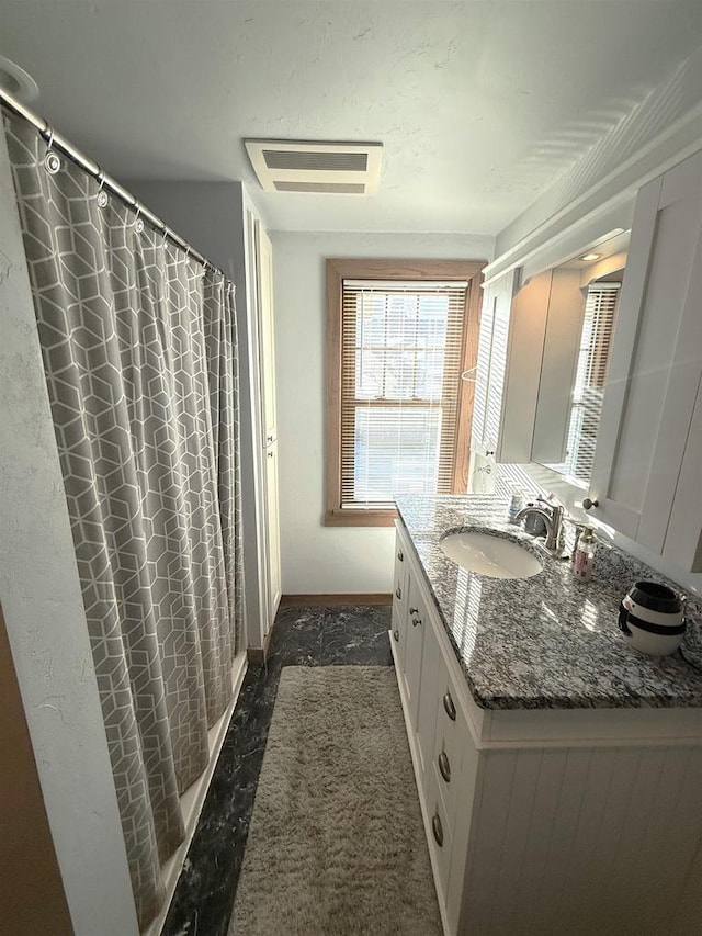 bathroom with walk in shower and vanity