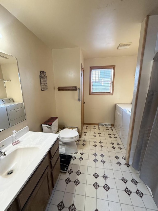 bathroom featuring toilet, independent washer and dryer, and vanity