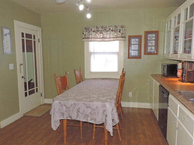 dining area with rail lighting and dark hardwood / wood-style floors