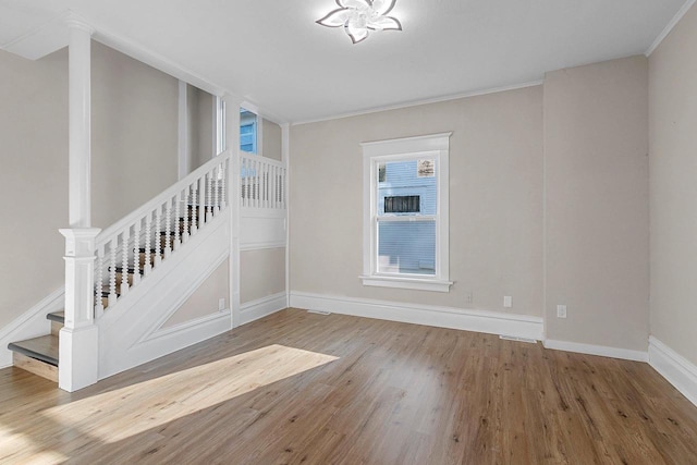 empty room with crown molding and hardwood / wood-style flooring