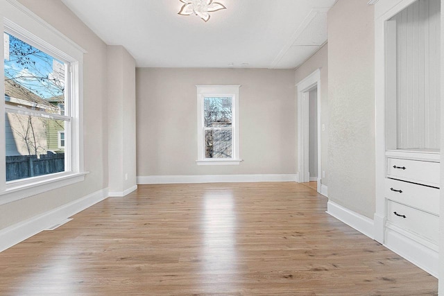 spare room with light hardwood / wood-style flooring and a wealth of natural light