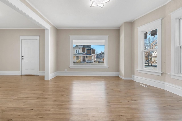 unfurnished living room featuring ornamental molding and light hardwood / wood-style floors