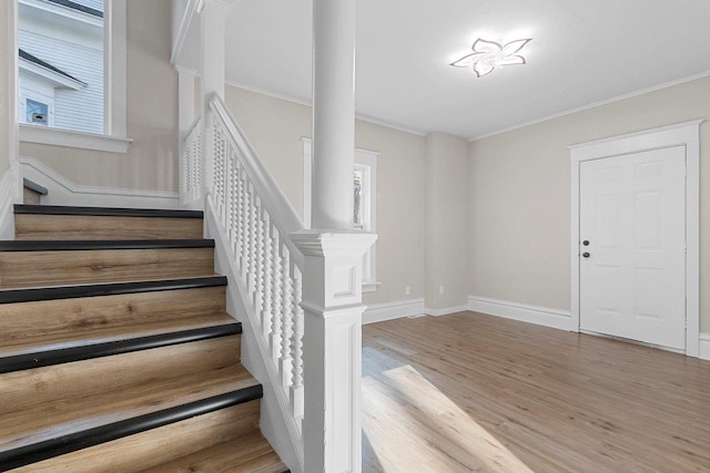 entryway with a wealth of natural light, hardwood / wood-style floors, and crown molding