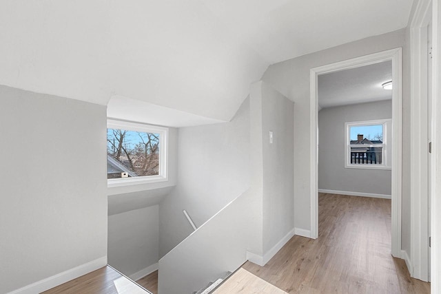 corridor featuring lofted ceiling and light hardwood / wood-style flooring