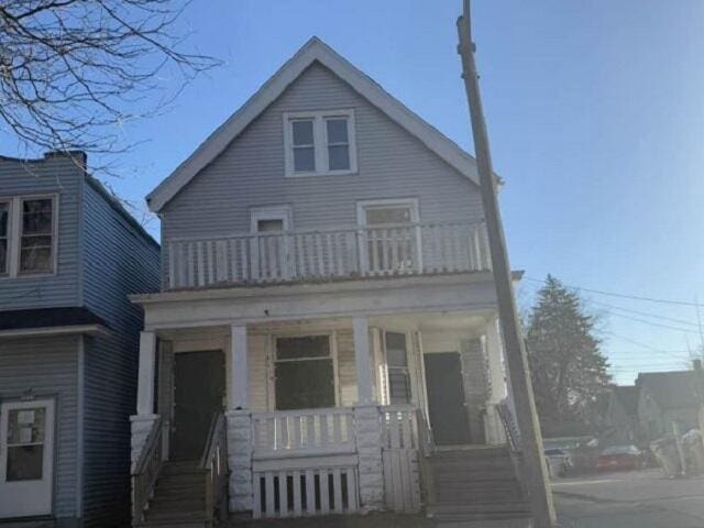 view of front of house with a porch and a balcony