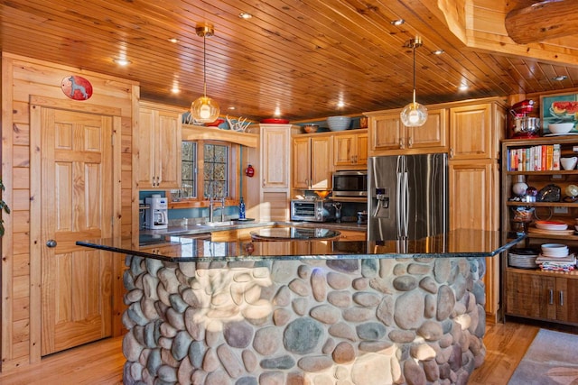 kitchen with stainless steel appliances, light wood-type flooring, hanging light fixtures, dark stone counters, and sink