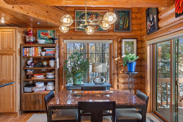 dining space with wooden ceiling, rustic walls, and light hardwood / wood-style flooring