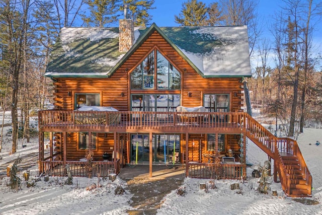 snow covered house featuring a deck