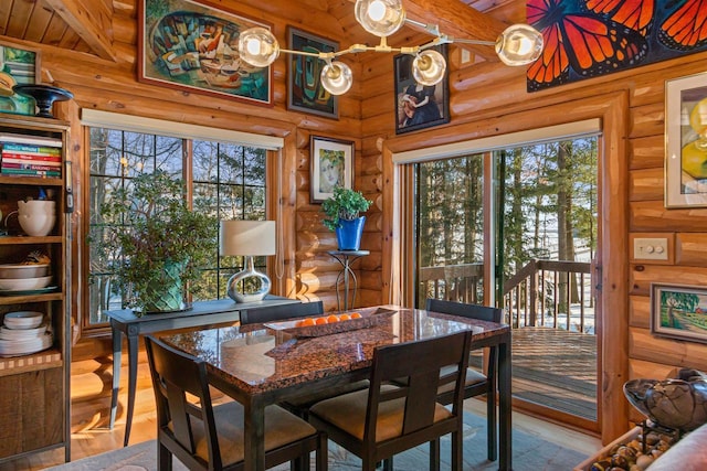 dining space with wood ceiling, rustic walls, and a wealth of natural light