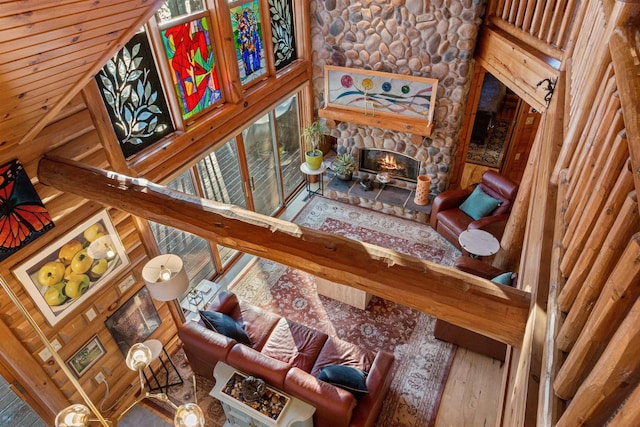 interior space with a towering ceiling, a fireplace, hardwood / wood-style floors, and beamed ceiling