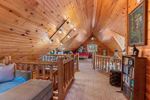 interior space with wooden walls, wooden ceiling, lofted ceiling, track lighting, and log walls