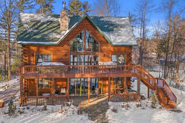 snow covered house with a wooden deck