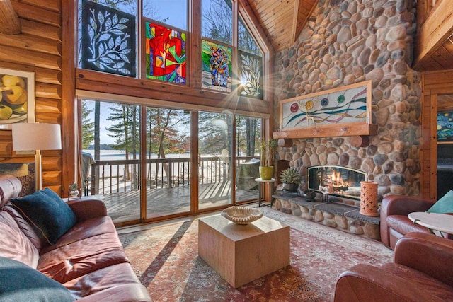 living room featuring a healthy amount of sunlight, high vaulted ceiling, log walls, wood ceiling, and a stone fireplace