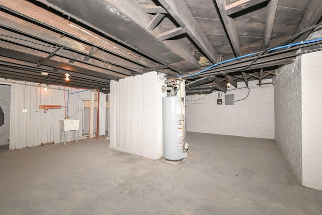 basement featuring water heater, brick wall, and electric panel