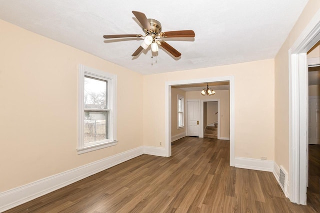 spare room featuring ceiling fan with notable chandelier and hardwood / wood-style floors