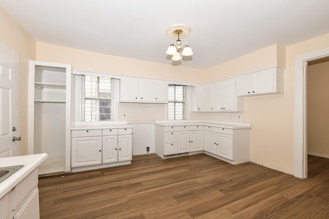 kitchen featuring a notable chandelier, pendant lighting, and white cabinetry