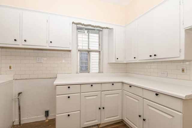 kitchen with white cabinets, dark hardwood / wood-style flooring, and decorative backsplash