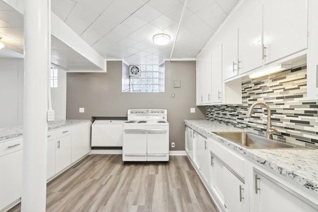 kitchen with white cabinetry, light wood-type flooring, range with two ovens, and sink