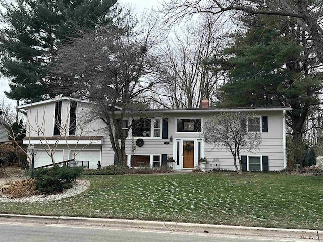 split foyer home featuring a front lawn and a garage