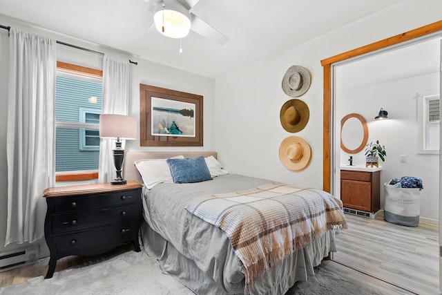 bedroom with ceiling fan, a baseboard radiator, and light hardwood / wood-style floors