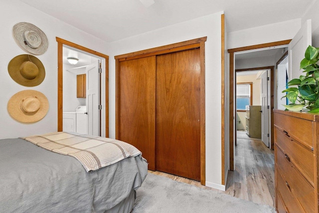 bedroom featuring washer and dryer, a closet, and light hardwood / wood-style flooring