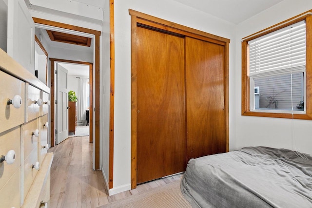 bedroom with light hardwood / wood-style flooring and a closet