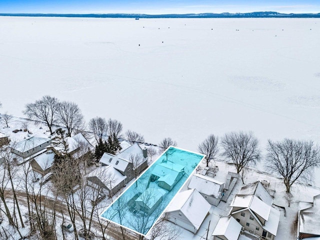 snowy aerial view featuring a water view