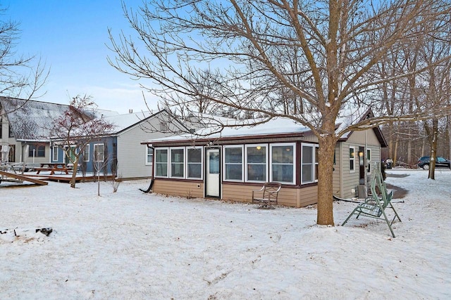 snow covered property with a sunroom