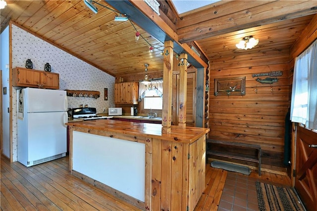 kitchen with white fridge, range, wood counters, sink, and decorative light fixtures