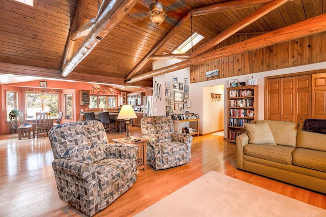 living room with beamed ceiling, high vaulted ceiling, light wood-type flooring, and wood ceiling