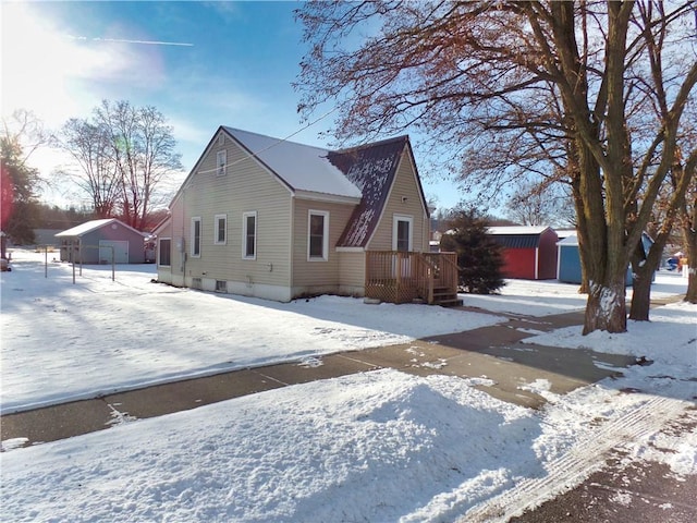 view of snow covered exterior featuring a shed