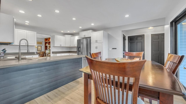 dining space with sink and light hardwood / wood-style flooring