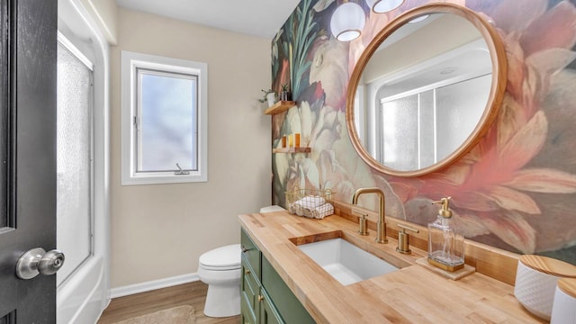 full bathroom featuring toilet, hardwood / wood-style flooring, enclosed tub / shower combo, and vanity