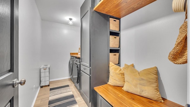 interior space with washer and clothes dryer, light wood-type flooring, and gray cabinets