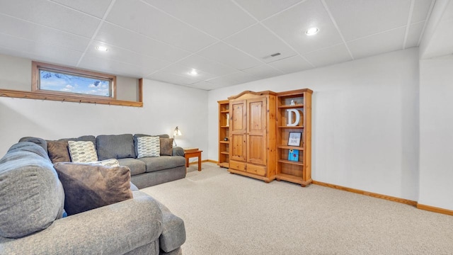 carpeted living room with a drop ceiling