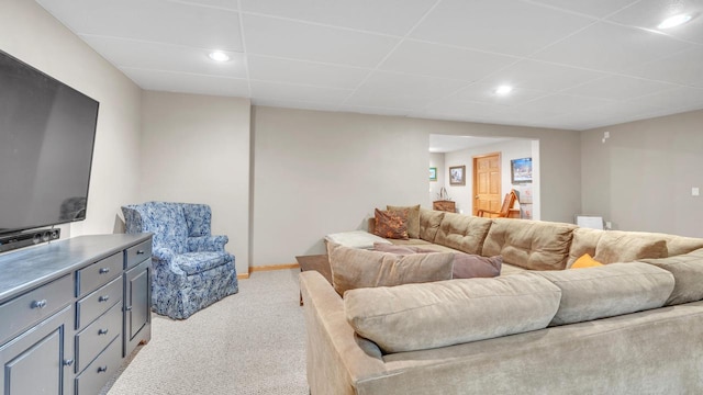 carpeted living room featuring a drop ceiling