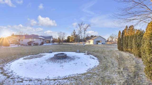 yard layered in snow featuring an outdoor fire pit