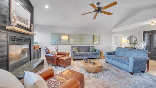 tiled living room featuring ceiling fan, lofted ceiling, and a fireplace