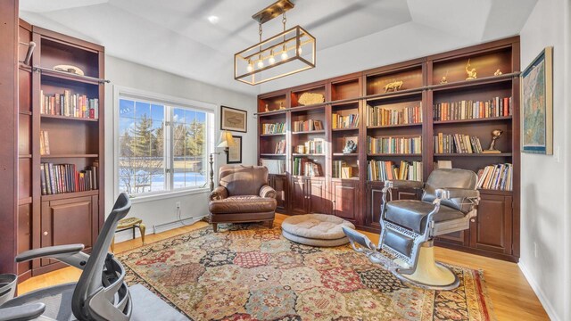 sitting room featuring a baseboard heating unit, a tray ceiling, and light hardwood / wood-style flooring